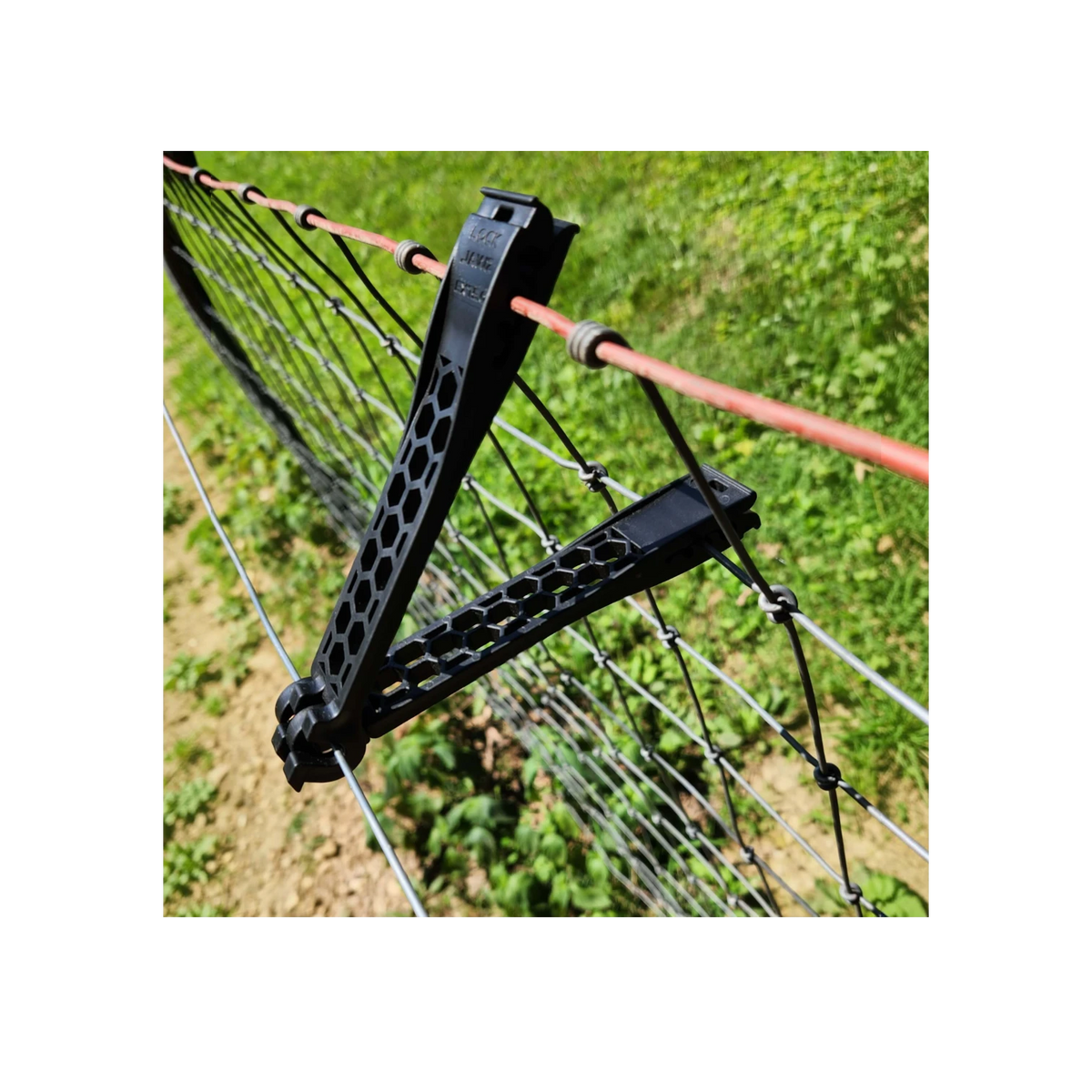 USA Grazing Systems LOCKJAWZ 5-inch black plastic extended electric fence insulator attached to wire fencing